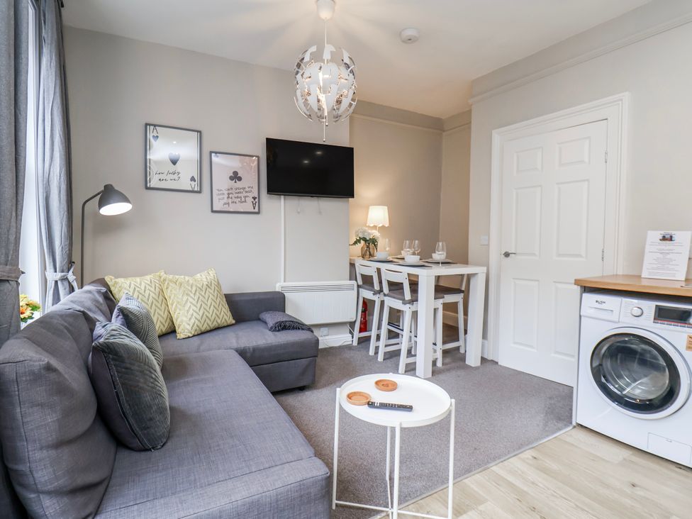 A living room with a sofa and dining area at 24 Baxtergate, Whitby