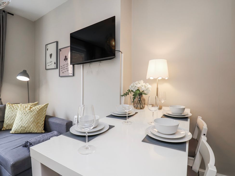 A living room with a dining table and sofa at 24 Baxtergate in Whitby