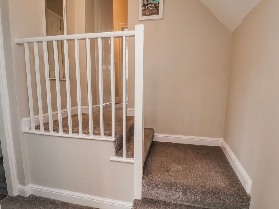 A staircase with white railing at 24 Baxtergate Whitby
