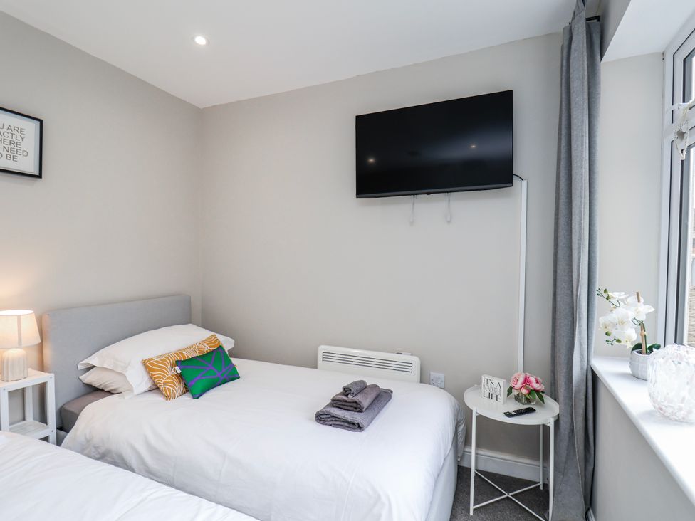 A bedroom with beds and a television at 24 Baxtergate in Whitby
