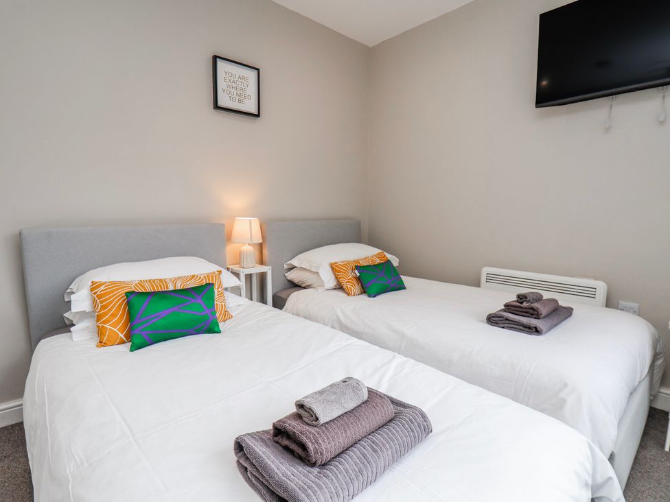 A bedroom with twin beds and a lamp at 24 Baxtergate in Whitby