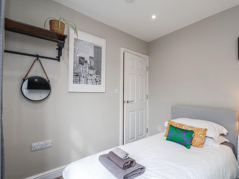 A bedroom with a bed and shelf at 24 Baxtergate in Whitby