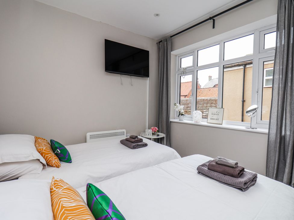 A bedroom with two beds and a television at 24 Baxtergate in Whitby