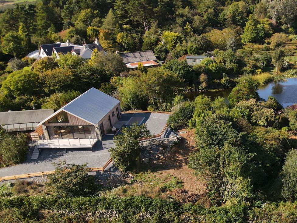 An outdoor area with a house and a pond at The Lodge in Dunragit near Glenluce
