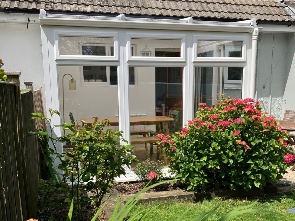 A conservatory with a table and chairs at Sea Spray in Port Isaac