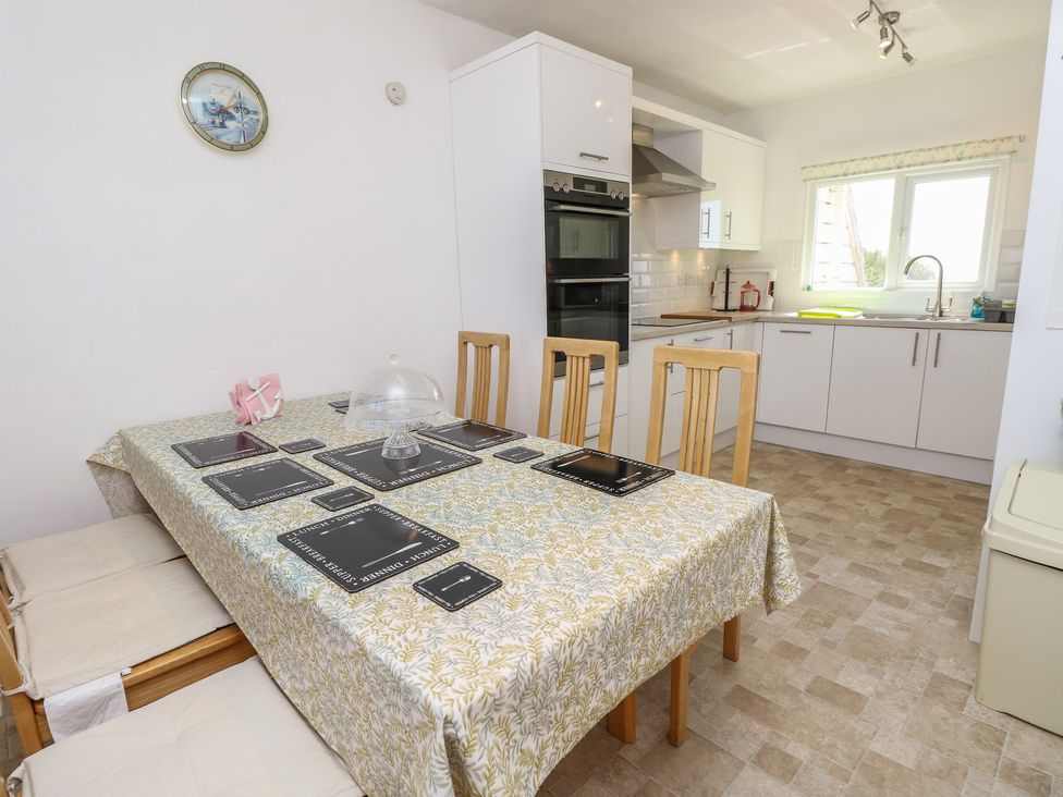 A dining room with a table and chairs at Bella Vista in Selsey, West Sussex