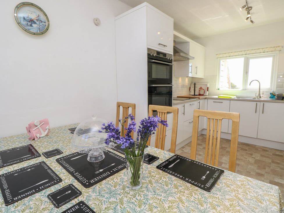 A kitchen with a dining table and chairs at Bella vista in Selsey, West Sussex