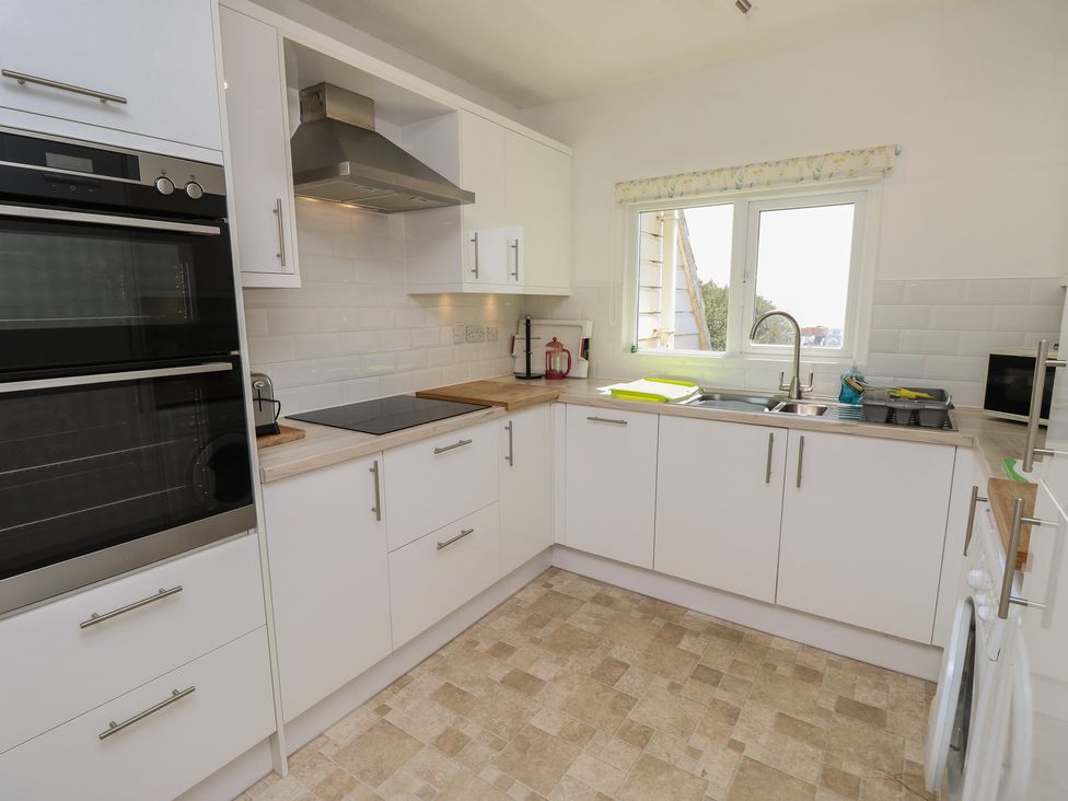 A kitchen with cabinets and appliances at Bella vista Selsey, West Sussex