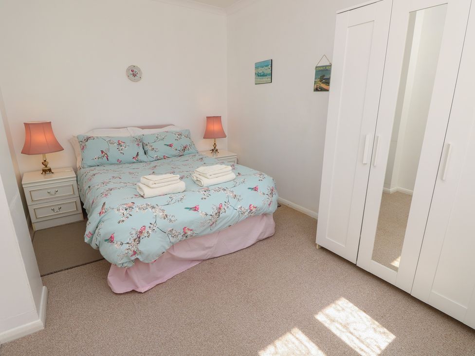 A bedroom with a bed and nightstand at Bella vista Selsey, West Sussex