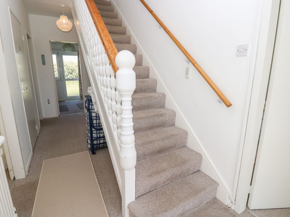 A staircase with a handrail in a hallway at Bella vista Selsey, West Sussex