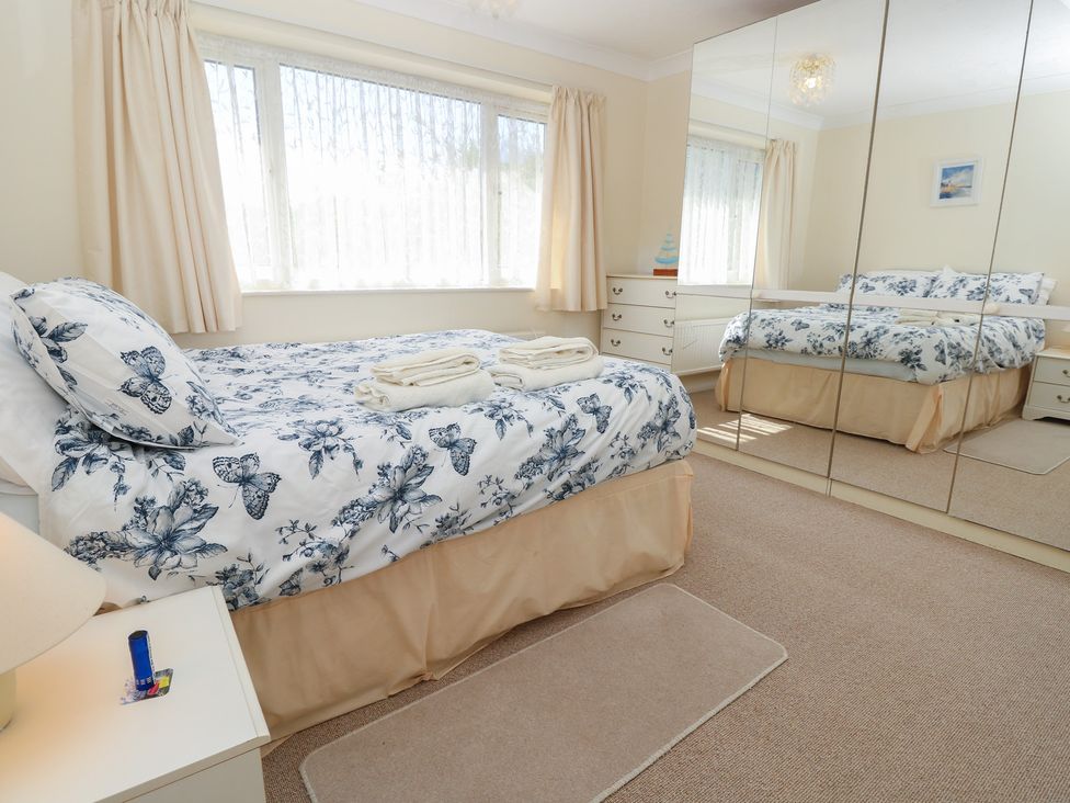 A bedroom with a bed and dresser at Bella vista in Selsey, West Sussex