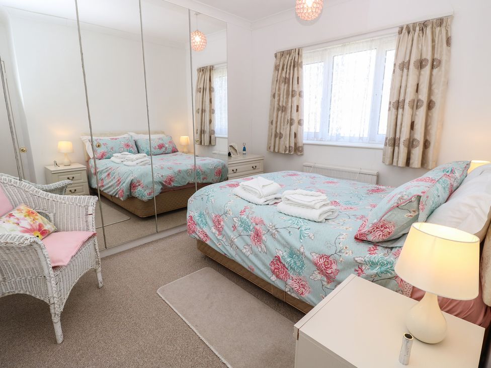 A bedroom with a bed and armchair at Bella vista in Selsey, West Sussex
