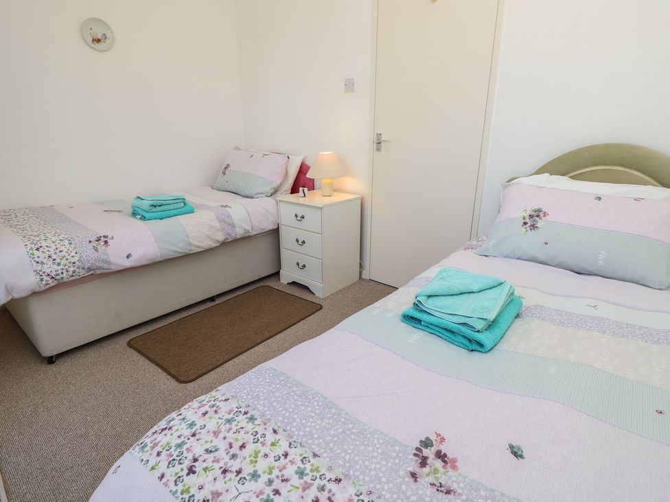 A bedroom with two beds and a nightstand at Bella vista in Selsey, West Sussex