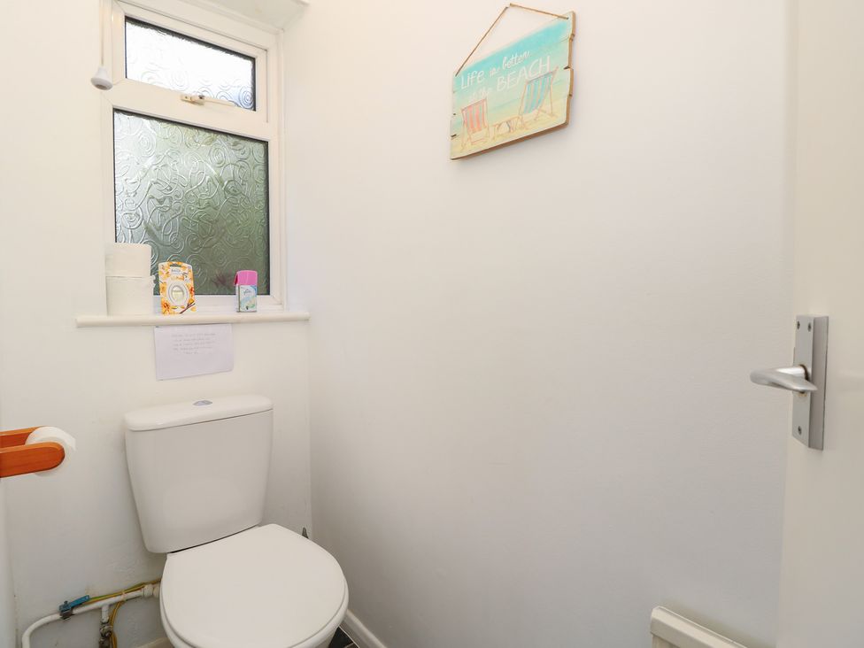 A bathroom with a toilet and window at Bella vista in Selsey, West Sussex