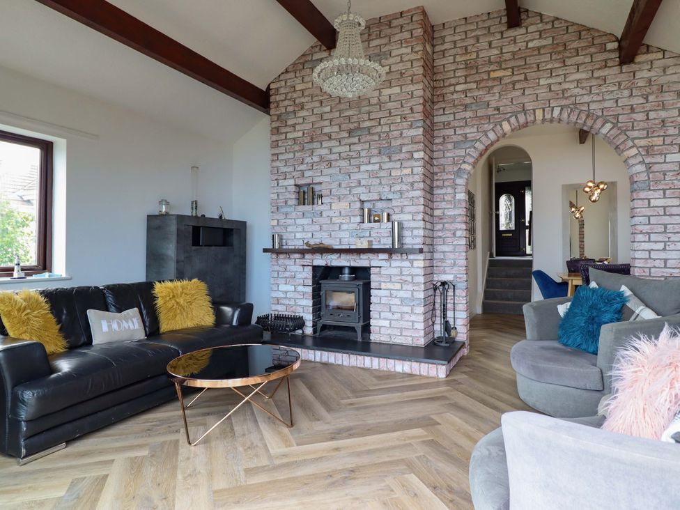 A living room with a sofa and a fireplace at Ser a Mor (Stars and Sea) Bull Bay near Amlwch