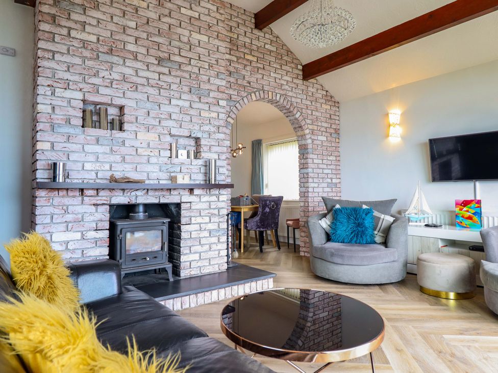 A living room with a fireplace and sofa at Ser a Mor (Stars and Sea) Bull Bay near Amlwch