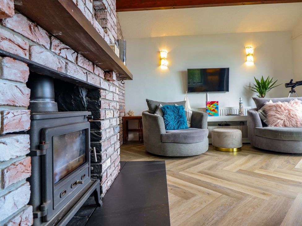 A living room with a fireplace and television at Ser a Mor (Stars and Sea) Bull Bay near Amlwch