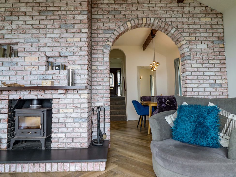 A living room with a fireplace and stairs at Ser a Mor (Stars and Sea) Bull Bay near Amlwch