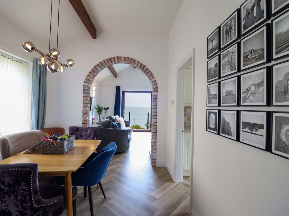 A dining room with a table and chairs at Ser a Mor (Stars and Sea) Bull Bay near Amlwch