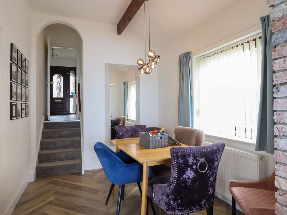 A dining area with a table and chairs at Ser a Mor (Stars and Sea) Bull Bay near Amlwch