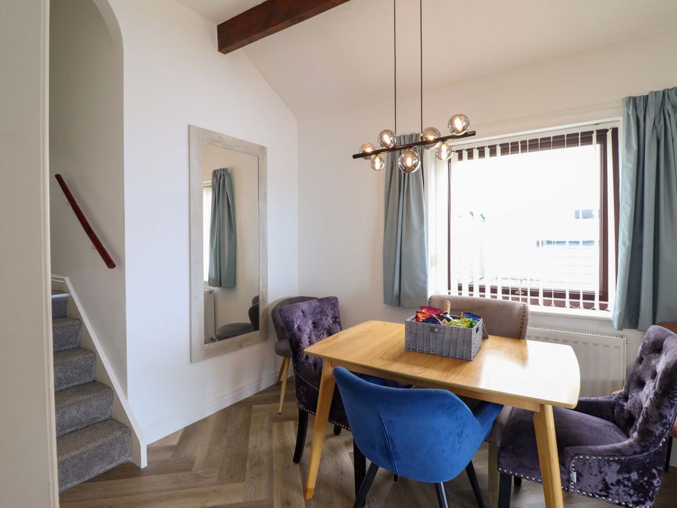 A dining room with a table and chairs at Ser a Mor (Stars and Sea) Bull Bay near Amlwch