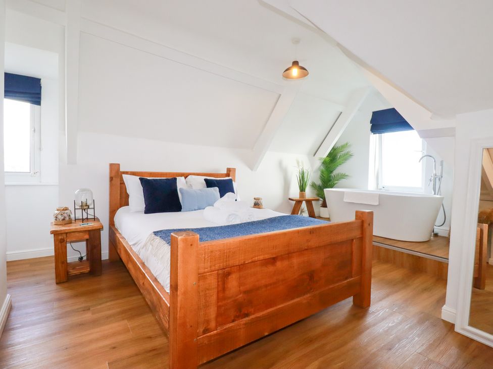 A bedroom with a bed and a bathtub at 5 St Gwithian Apartments