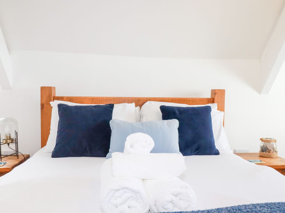 A bed with pillows and towels in a bedroom at 5 St Gwithian Apartments