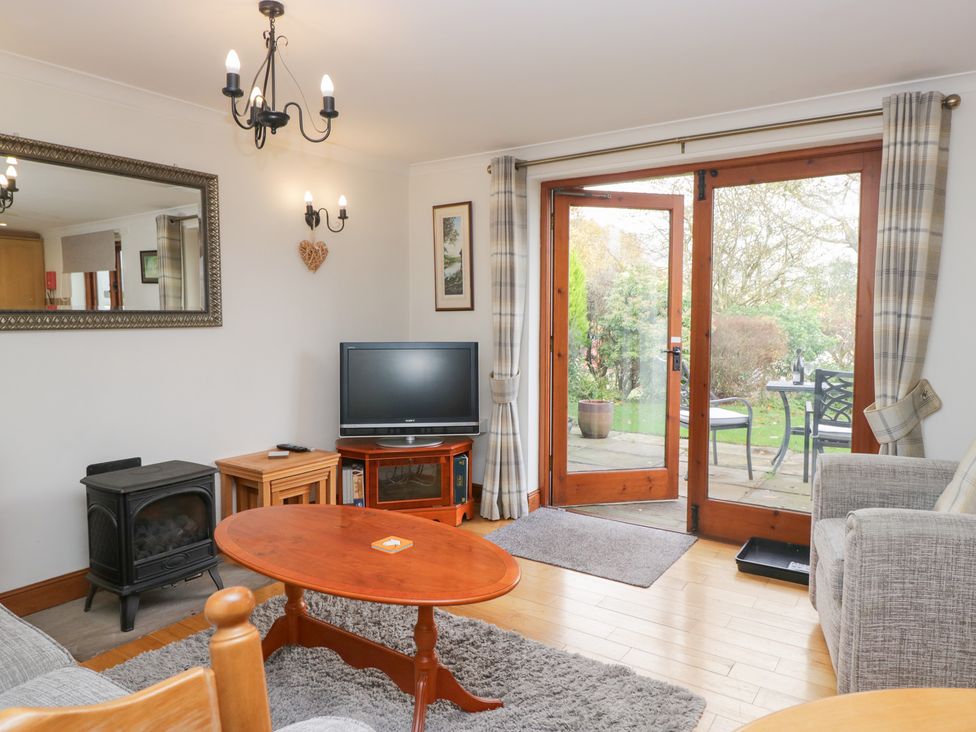 A living room with a television, sofa and coffee table at Low Dow Crag in Coniston