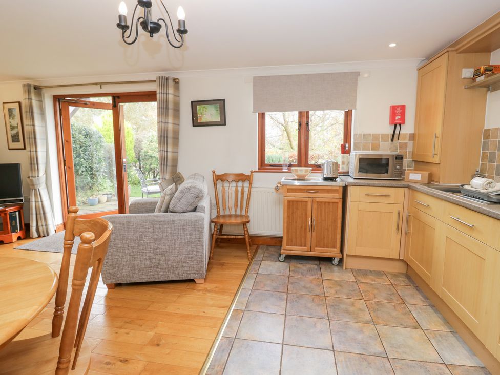 A kitchen with dining area and appliances at Low Dow Crag in Coniston