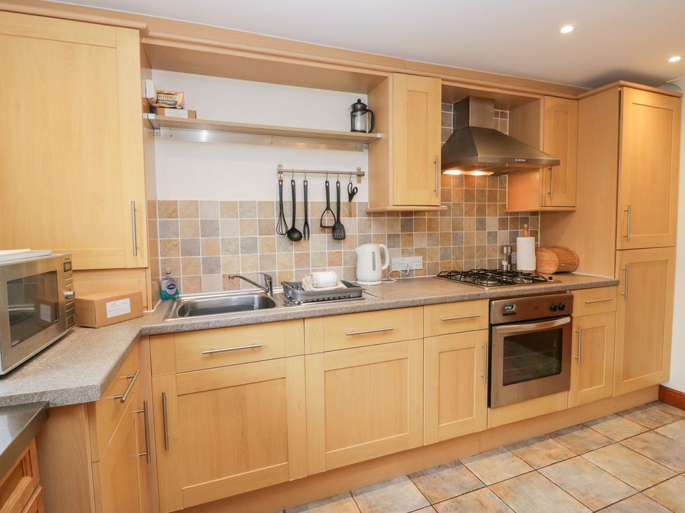 A kitchen with cabinets, sink, stove, and microwave at Low Dow Crag in Coniston