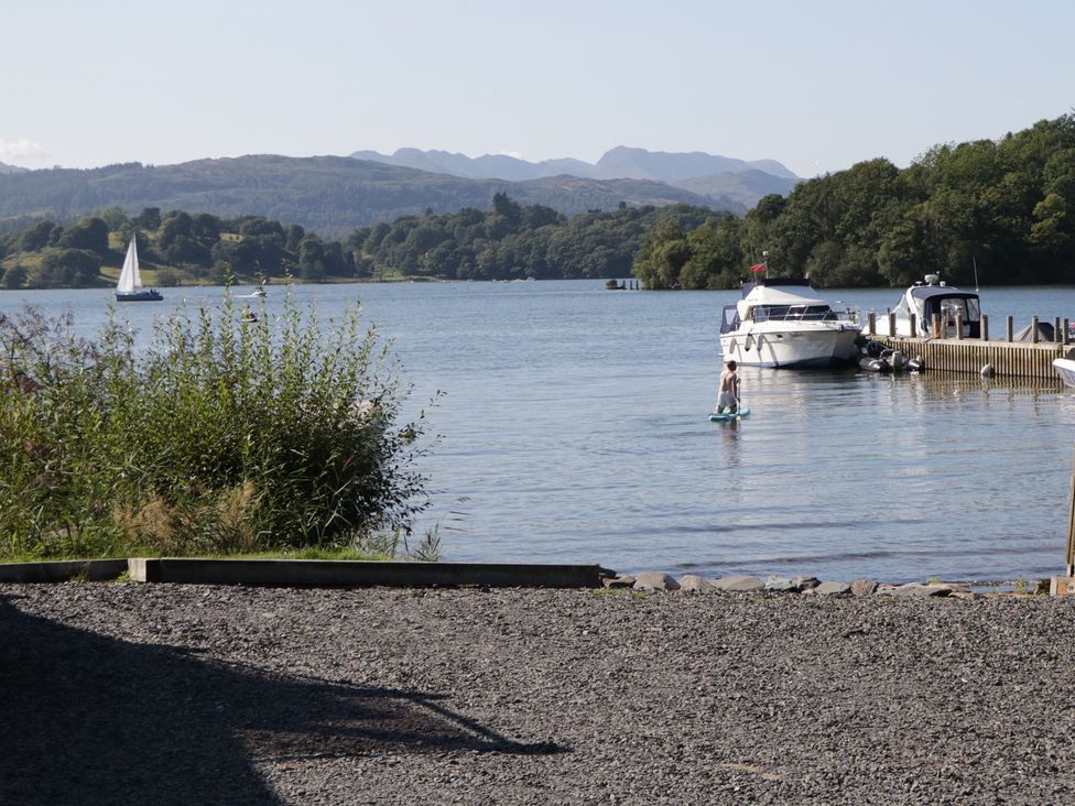 A water scene with boats and a person on a paddle board at Low Dow Crag in Coniston