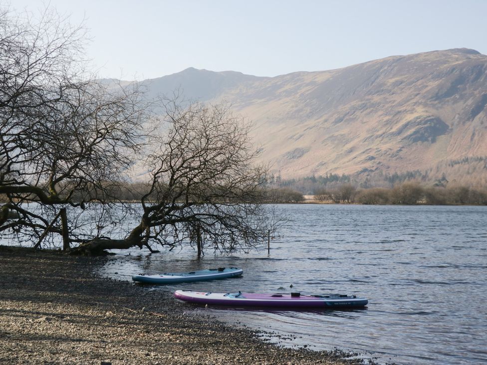 A lake with kayaks and mountains in the background at Low Dow Crag in Coniston