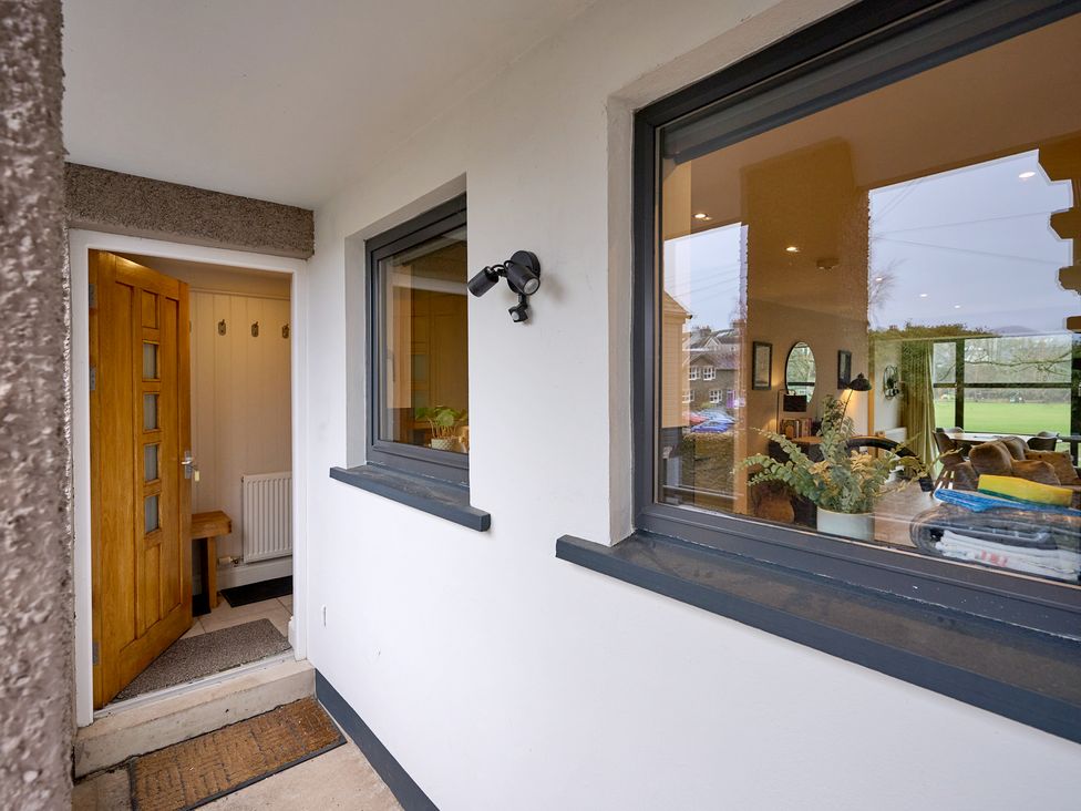 An entrance with a wooden door and a bench at Riverside Park 3 in Keswick