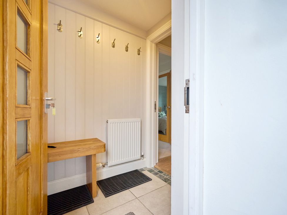 A hallway with hooks and a bench at Riverside Park 3 in Keswick