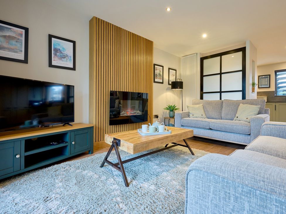 A living room with a television, sofa, and coffee table at Riverside Park 3 in Keswick
