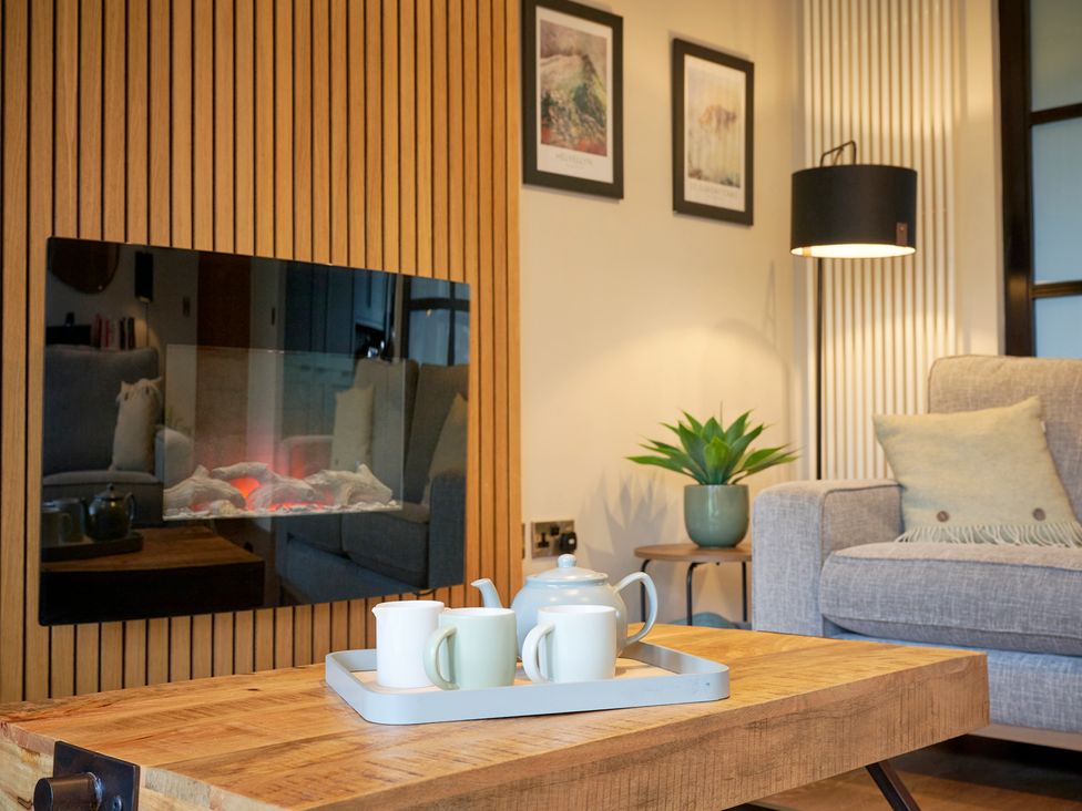 A living room with a coffee table, sofa and fireplace at Riverside Park 3 in Keswick