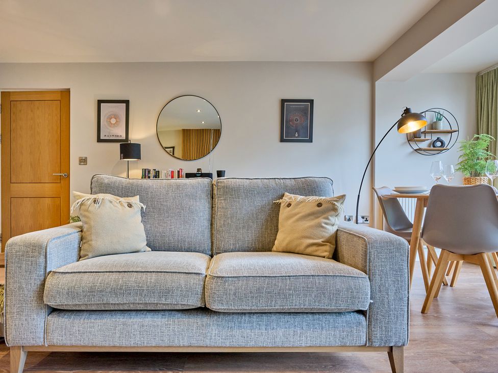 A living room with a sofa and a dining area at Riverside Park 3 in Keswick