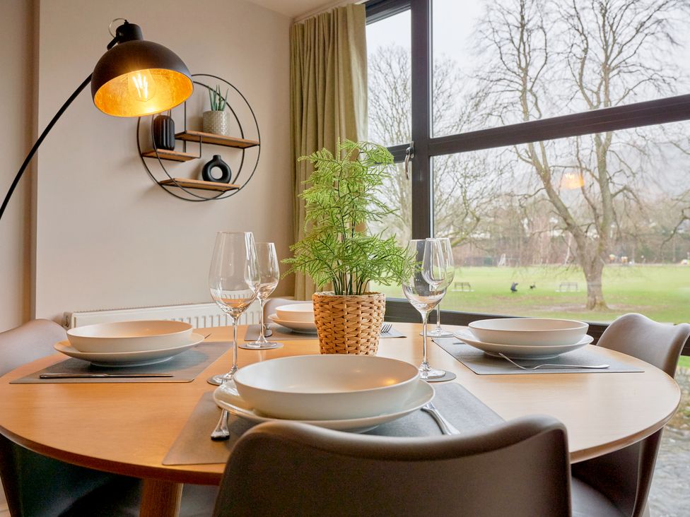 A dining room with a round table set for dinner at Riverside Park 3 in Keswick