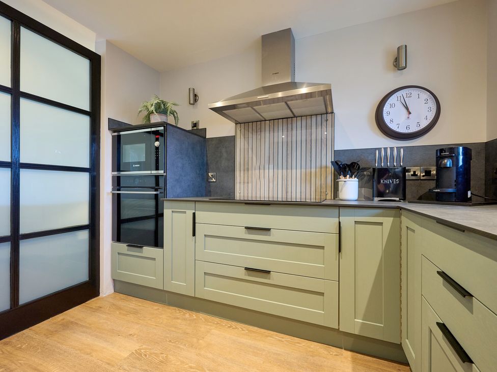A kitchen with cabinets, appliances and utensils at Riverside Park 3 Keswick