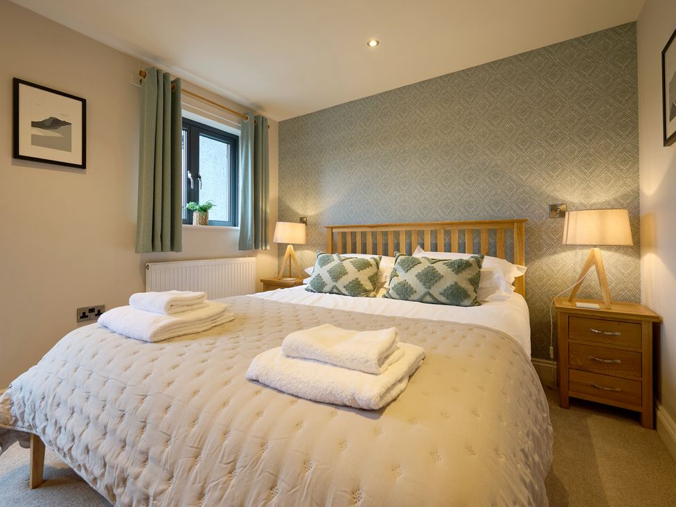 A bedroom with a bed and bedside table at Riverside Park 3 in Keswick