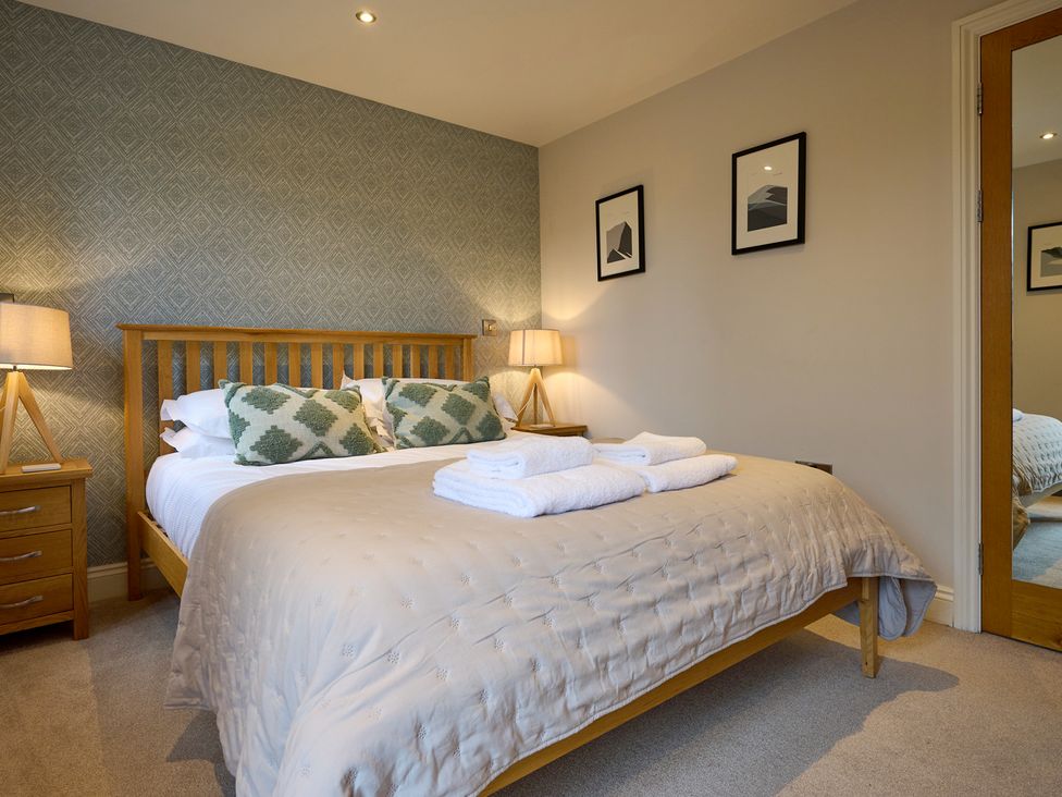 A bedroom with a bed and bedside table at Riverside Park 3 Keswick