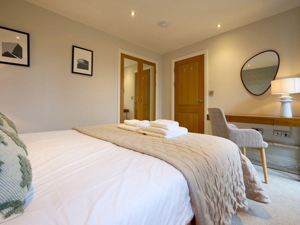 A bedroom with a bed and desk at Riverside Park 3 in Keswick