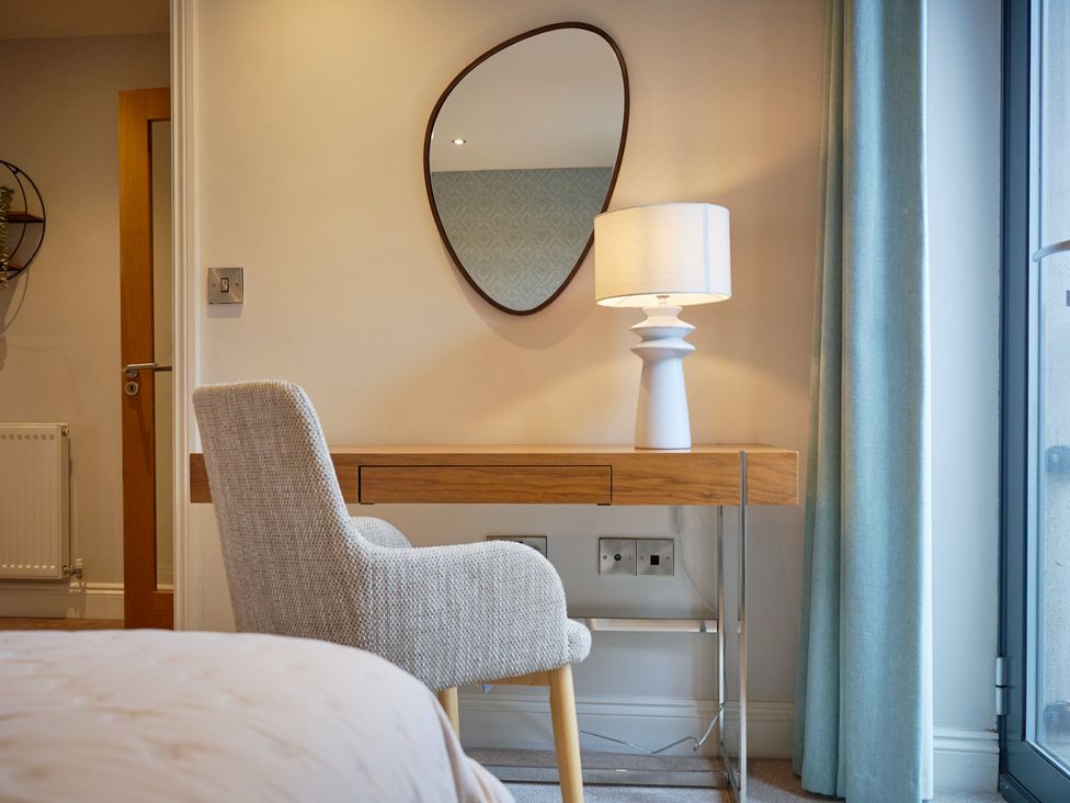 A bedroom with a desk and lamp at Riverside Park 3 in Keswick