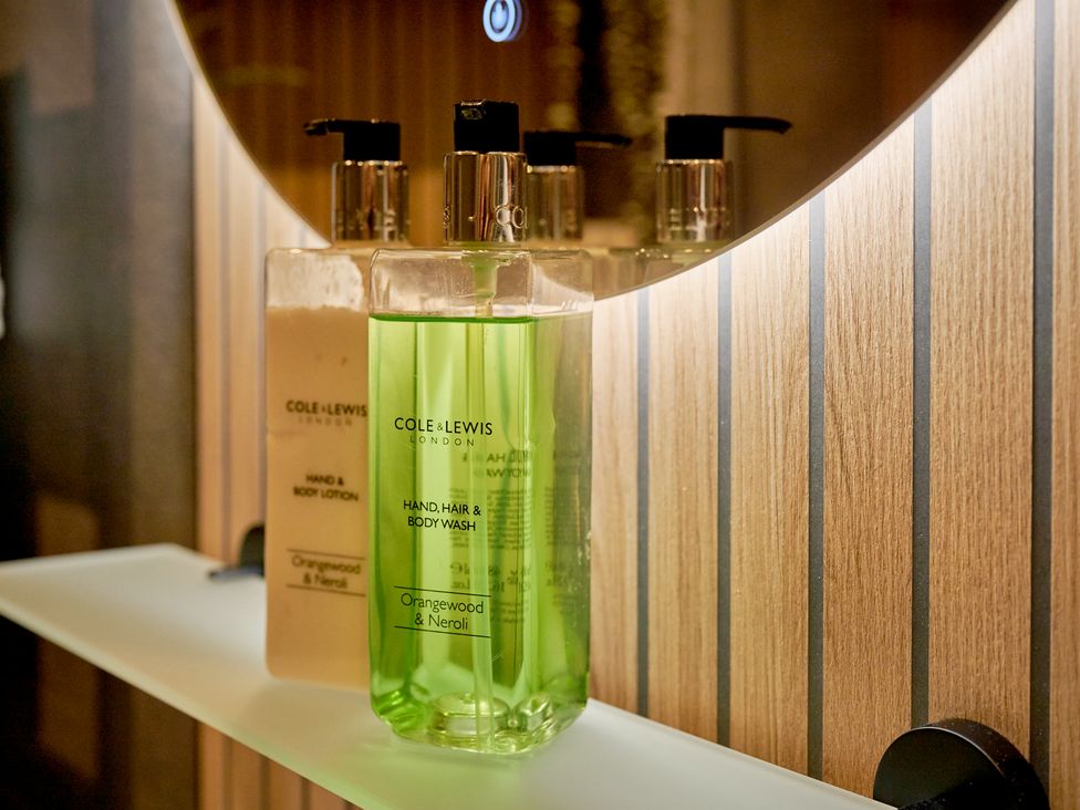 A bathroom shelf with hand and body lotion and body wash at Riverside Park 3 in Keswick