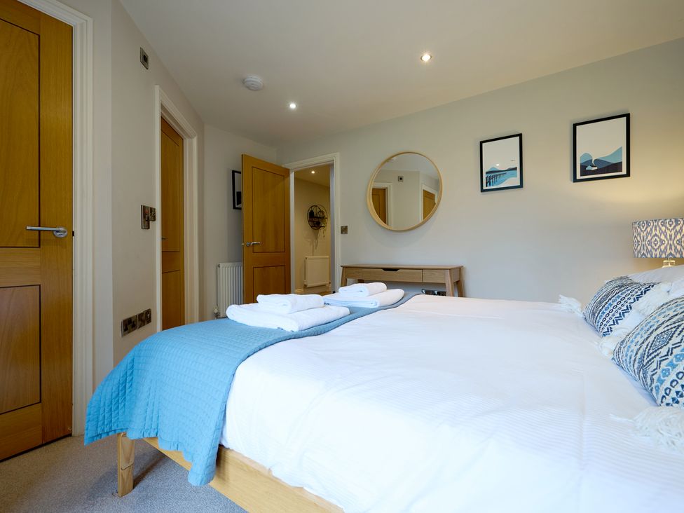 A bedroom with a bed and mirror at Riverside Park 3 in Keswick