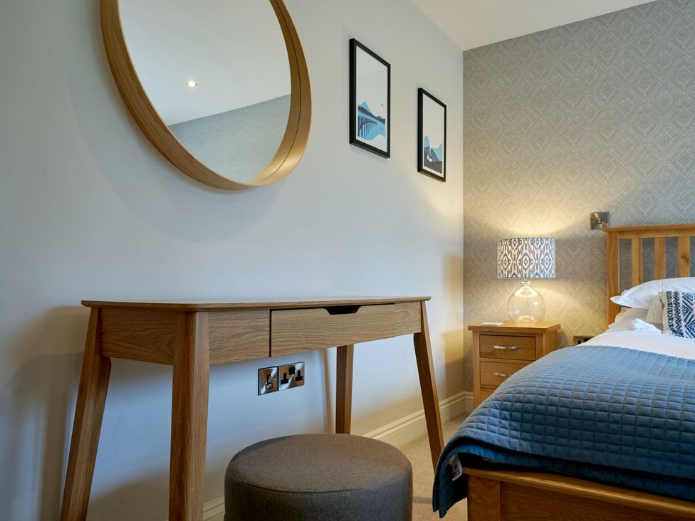 A bedroom with a bed, desk, and lamp at Riverside Park 3 in Keswick