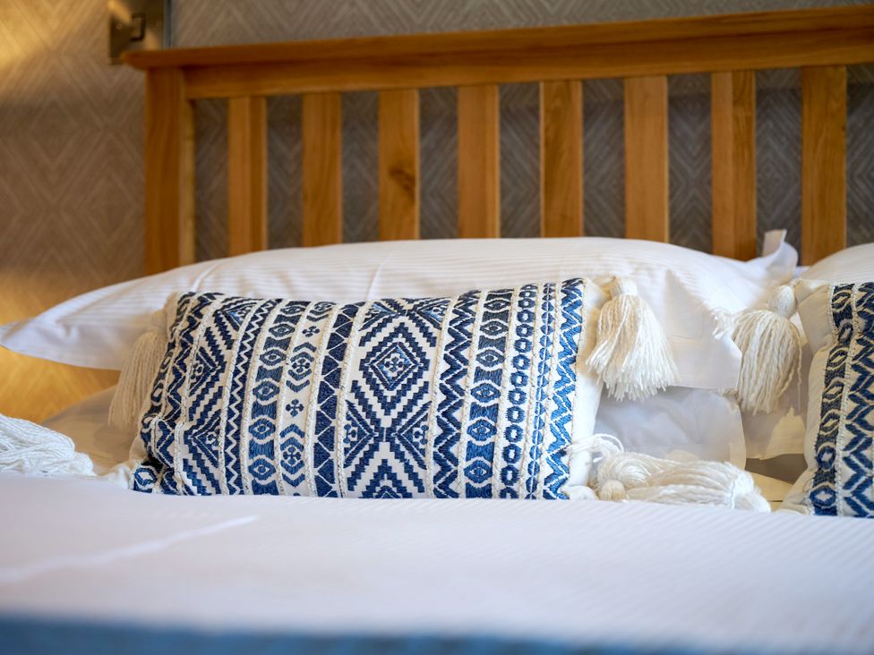 A bed with decorative pillows at Riverside Park 3 in Keswick