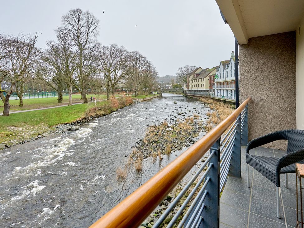A river flowing near buildings and trees at Riverside Park 3 in Keswick