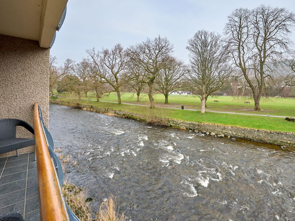 A view from a balcony overlooking a river and park at Riverside Park 3 in Keswick