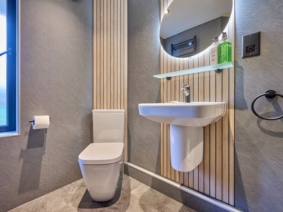 A bathroom with a toilet and sink at Riverside Park 3 in Keswick